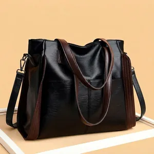 Large capacity black soft leather tote bag with brown straps detail view