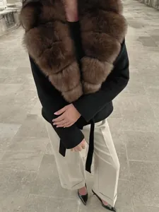 Primer plano de un abrigo de lana negro con un elegante cuello de piel sintética marrón.