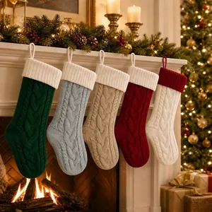 Set aus fünf großen grob gestrickten Weihnachtsstrümpfen am Kamin als Geschenktüten