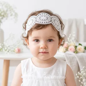 Delicate white floral lace headband worn by a baby girl for 1st birthday photos