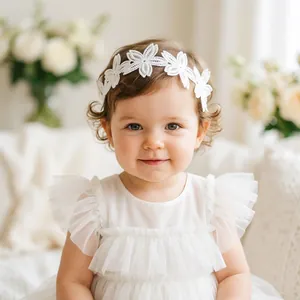 Close-up of white lace baby headband featuring elegant floral embroidery for newborns