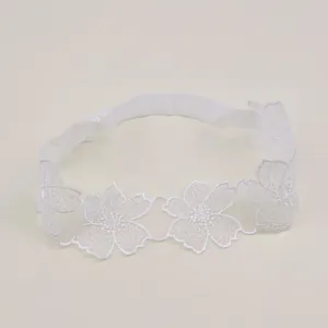 Detailed close-up view of a soft baby lace headband with delicate white flower embroidery