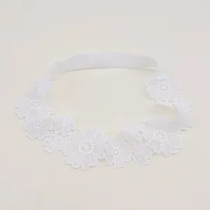 Detailed view of the delicate white floral embroidery pattern on a soft baby lace headband