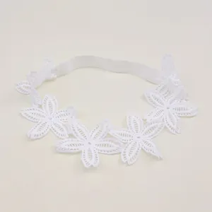 Close-up of white baby lace headband with embroidered flower details for infant photos