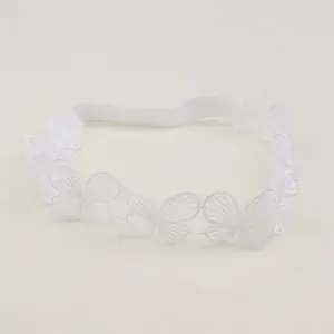 Detailed view of delicate white lace baby headband with embroidered butterfly patterns