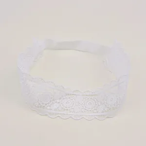 Close-up detail of white lace baby headband featuring exquisite floral embroidery patterns