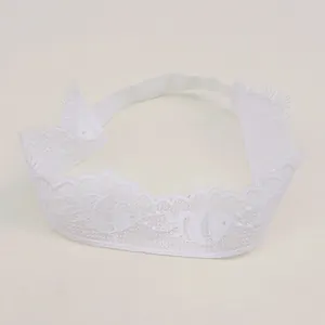 Detailed view of white baby lace headband with delicate fish embroidery and soft mesh