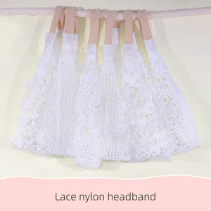 Detail showing various white lace baby headbands with delicate floral embroidery and nylon