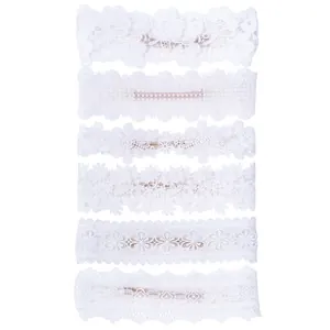 Set of six delicate white lace baby headbands with floral embroidery details.