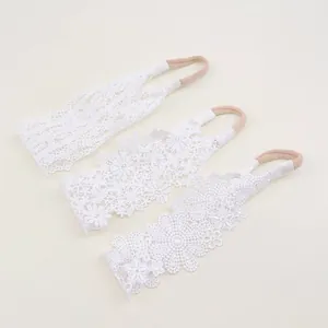 Detailed view of three exquisite white lace floral baby headbands with soft elastic