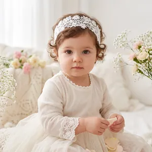 Close-up of baby girl wearing white floral lace headband for photography sessions
