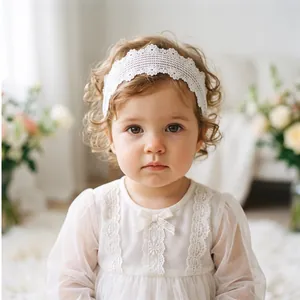 Close-up of baby girl wearing white lace headband with delicate flower embroidery.