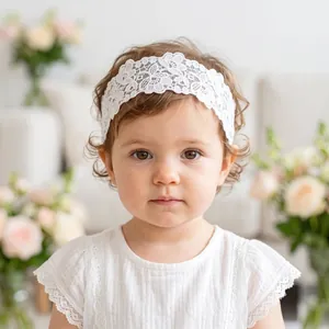 Close-up detail of a soft white embroidered floral lace headband on a toddler girl
