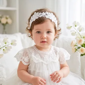 Detailed view of baby girl wearing an elegant white floral embroidery lace headband