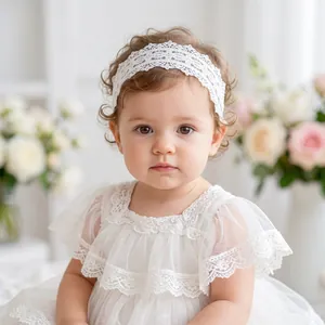 Close-up of white lace baby headband and matching floral embroidery dress on a toddler