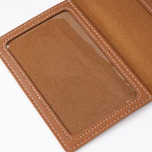 Close-up detail of a brown leather passport holder showing clear internal PVC ID window