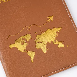 Close-up of brown PVC passport cover with golden world map and airplane detail