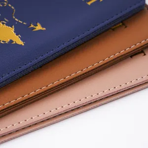 Detail view of the stitching and multi-color PVC passport covers with map patterns.