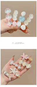 Primer plano de pasadores para el cabello con forma de concha y estrella de mar con perlas