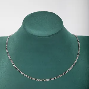 Close-up of a minimalist stainless steel 3:1 Figaro chain necklace on a display bust