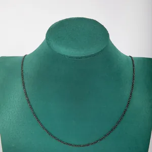 Detailed view of a dark stainless steel 3:1 Figaro NK chain necklace on a green bust
