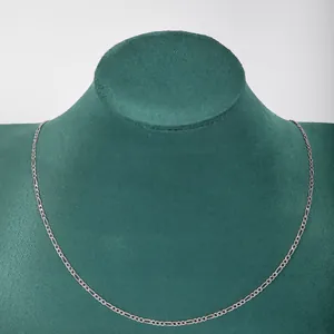 Detail view of a stainless steel 3:1 Figaro chain necklace on a green display bust.