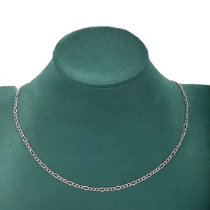 Minimalist silver stainless steel 3:1 Figaro chain necklace displayed on green velvet bust