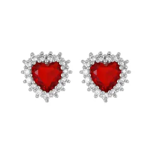 Close-up of red heart-shaped gemstone stud earrings with micro-paved zircon halo