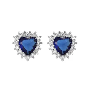 Close-up of heart-shaped blue gemstone earrings with micro-paved zircons
