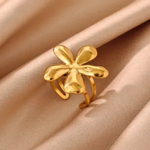Detailed close-up view of an elegant golden flower ring placed on champagne silk fabric