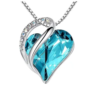 Close-up detail of elegant blue heart-shaped birthstone necklace with crystal accents
