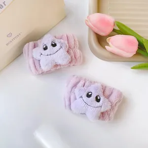 Dettaglio polsini in peluche viola con simpatica stella sorridente per cura della pelle