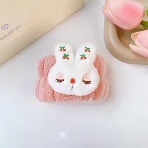 Dettaglio di un polsino in peluche rosa per il lavaggio del viso con un coniglietto