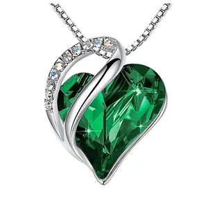 Macro view of emerald green heart-shaped crystal pendant with silver-tone chain