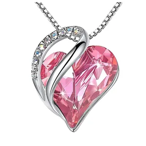 Detailed close-up of a pink heart-shaped crystal birthstone pendant with zircon accents.