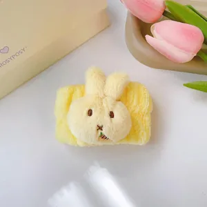 Dettaglio di un polsino in peluche giallo con coniglietto per lavare il viso