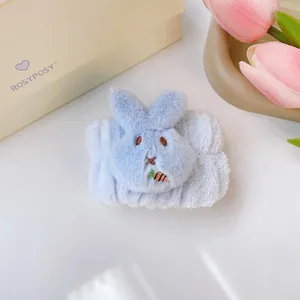 Dettaglio di un morbido polsino in peluche blu con un simpatico coniglio per lavare il viso