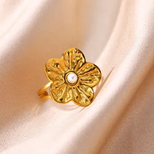Detailed macro shot of a golden stainless steel flower ring with a center pearl element