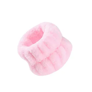 Primo piano della morbida consistenza dei polsini in flanella rosa per lavare il viso.