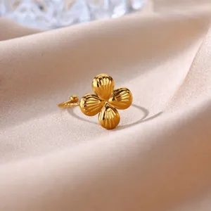 Macro view of a gold-plated stainless steel ring with a textured four-petal flower design