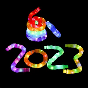 Vibrant glowing multi-colored LED pop tubes fidget toys arranged as 2023 in the dark