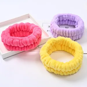 Primo piano di tre morbidi braccialetti in flanella nei colori rosa, viola e giallo