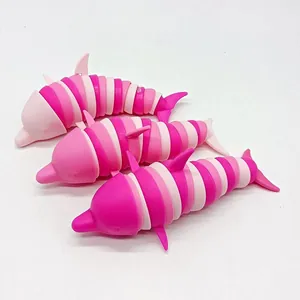 Nahaufnahme mit drei bunten 3D-gedruckten Gelenk-Delfinen als Antistress-Spielzeug auf Weiß