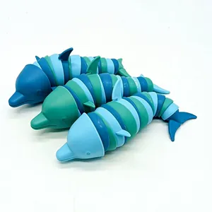 Detailansicht von drei beweglichen 3D-gedruckten Delphin-Zappelspielzeugen in Blau.
