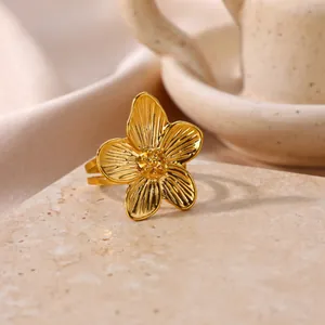 Elegant gold stainless steel flower ring with textured five-petal design on stone pedestal.