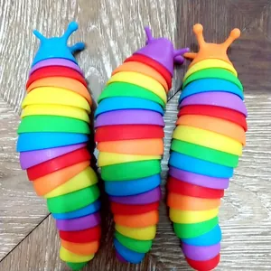 Detailansicht von drei bunten Regenbogen-Schnecken-Zappelspielzeugen auf Holzfläche