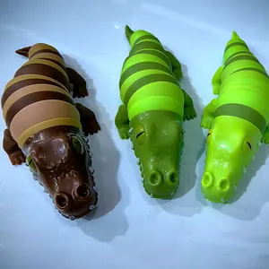 Detaillierte Ansicht von drei Krokodil-Antistress-Spielzeugen in Braun- und Grüntönen.