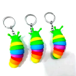 Nahaufnahme von drei regenbogenfarbenen Raupen-Zappelspielzeug-Schlüsselanhängern