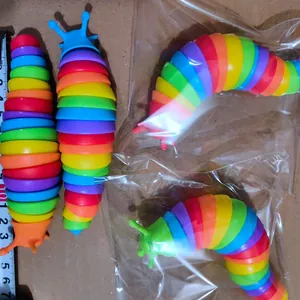 Makroansicht eines regenbogenfarbenen, beweglichen Schnecken-Fidget-Spielzeugs auf Karton