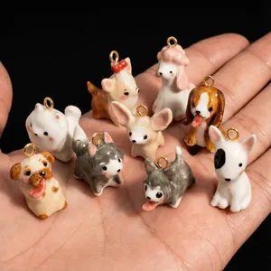 Handmade cartoon dog charms with colorful enamel finish on a palm